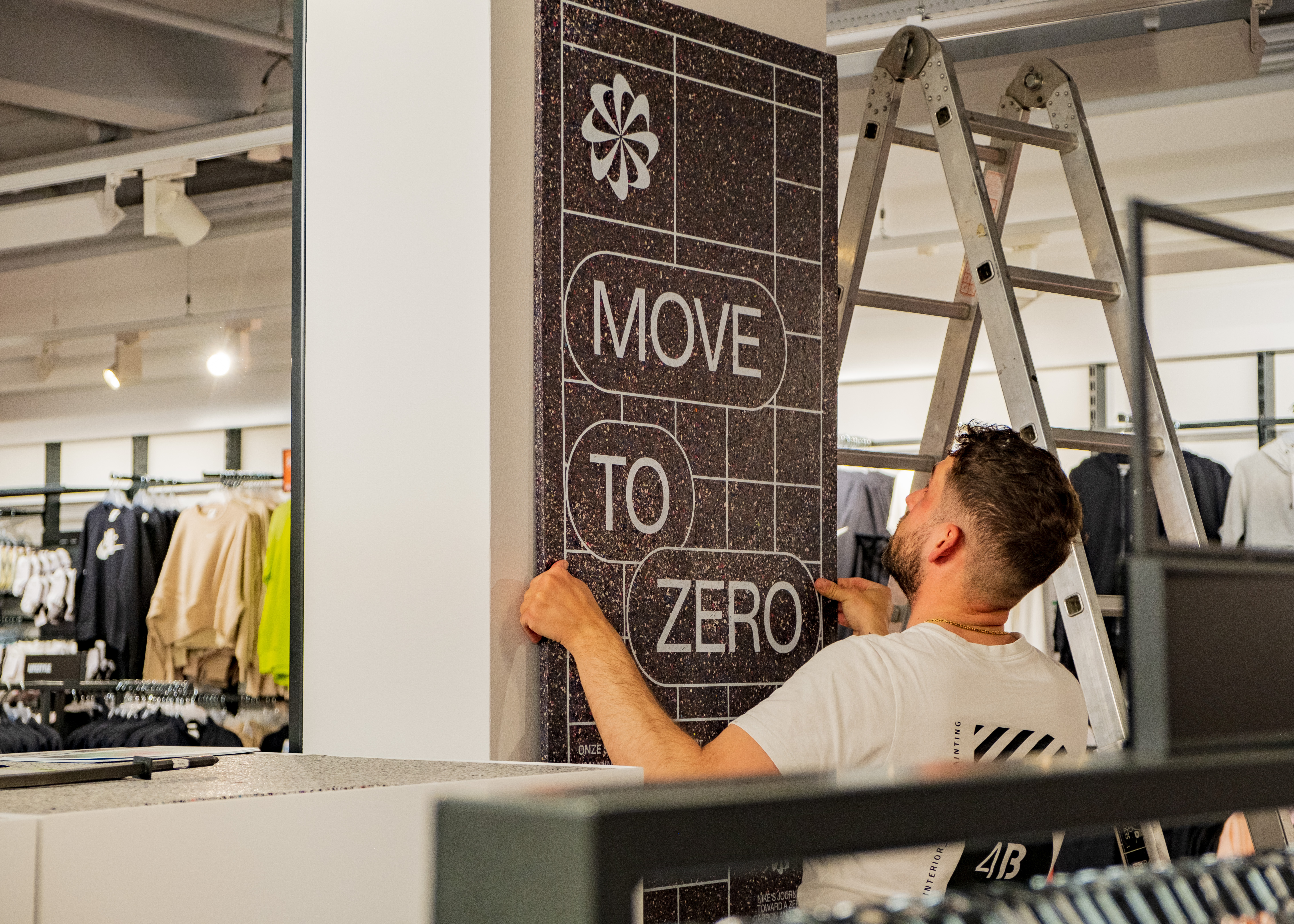 Nike associates installing Move to Zero branding in store