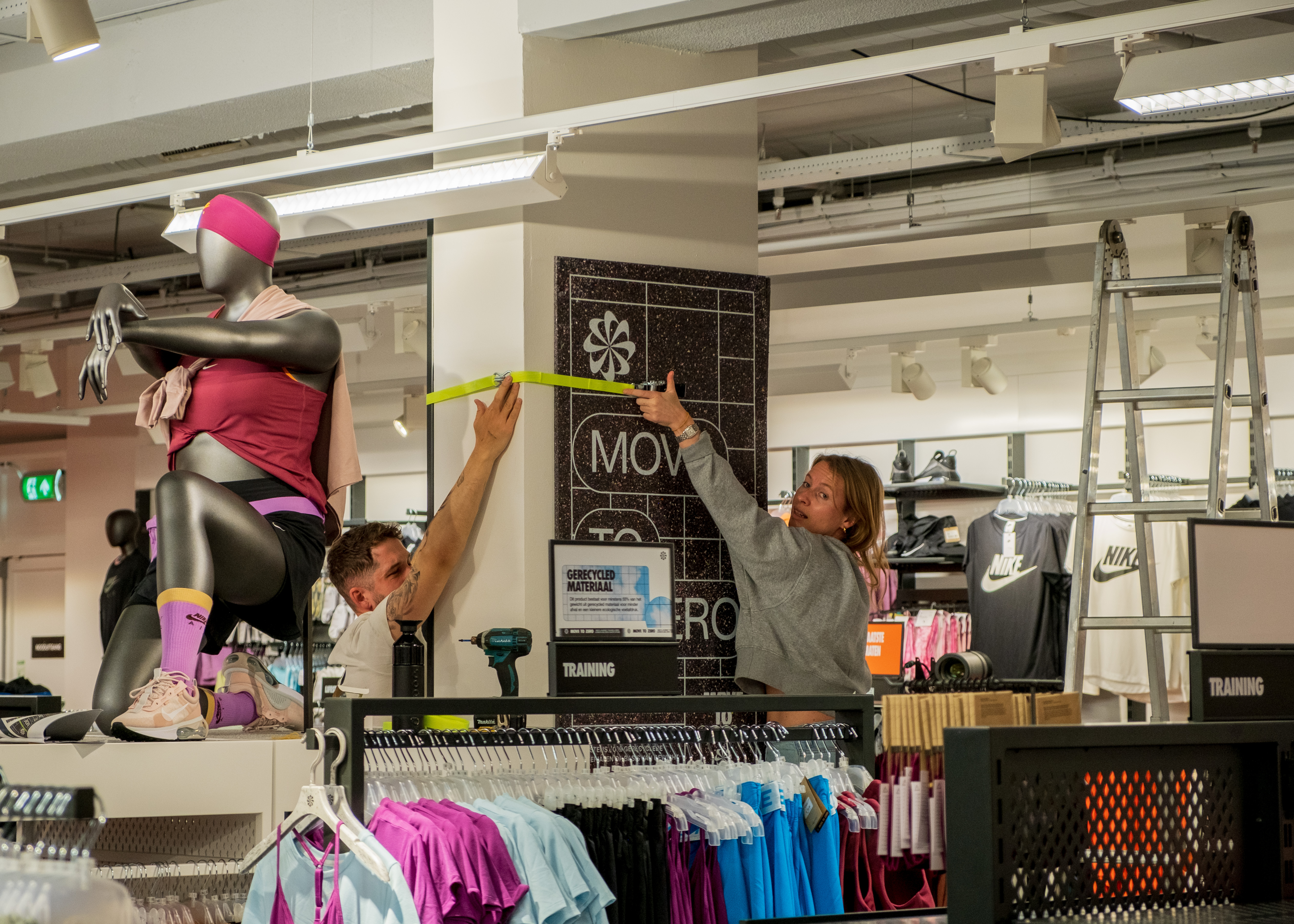 Nike associates installing sustainability campaign materials